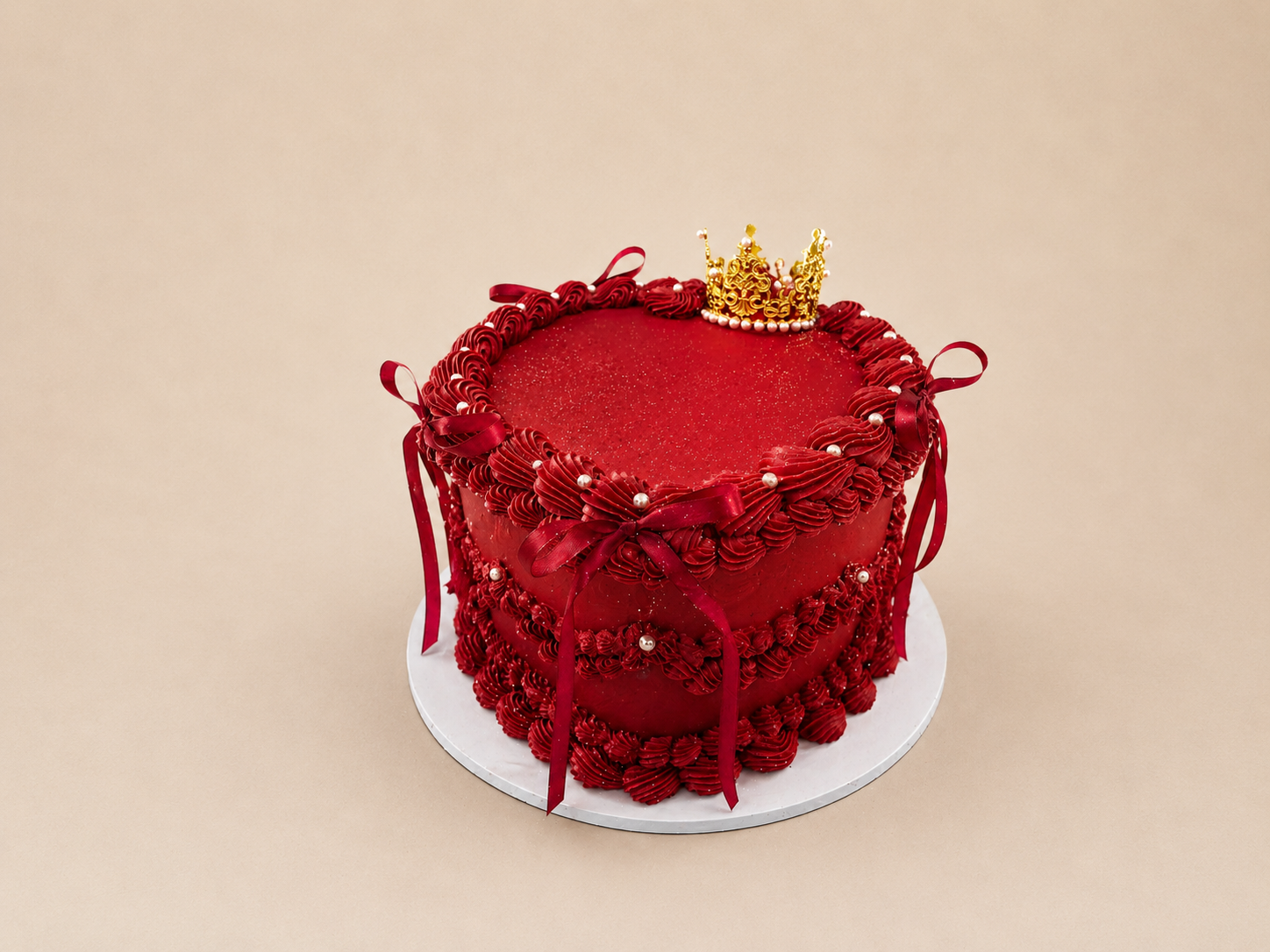 Custom Cakes Red velvet custom celebration cake with gold crown topper and ribbon details by Cakes by Teez in Abuja